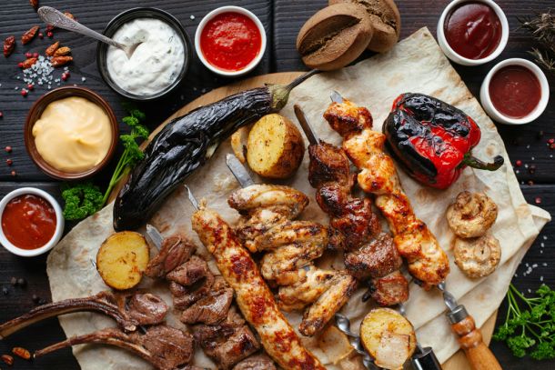 Grillplatte mit Fleisch, Gemüse und Saucen